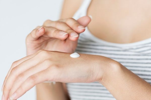 Liquen plano - imagen de las manos de una mujer blanca la cual esta usando una crema para aliviar los síntomas del liquen plano