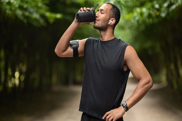 Ayuno intermitente - Hombre tomando agua para hidratarse tras entrenamiento 