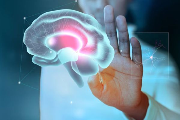 Afasia - imagen virtual del cerebro con una zona marcada en rojo por daños sufridos y un especialista revisando la imagen
