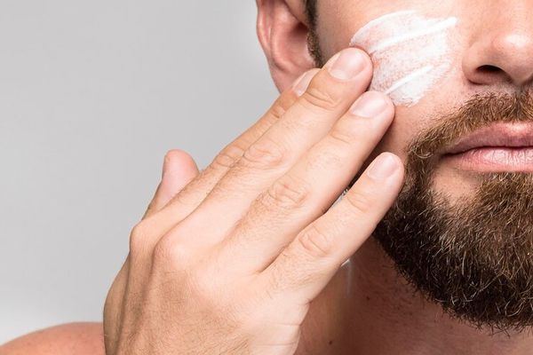 dermatitis seborreica - hombre blanco barbudo aplicándose una crema en la cara