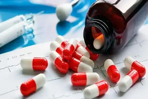 imagen de un bote de píldoras tumbado sobre la mesa del doctor con muchas píldoras caídas sobre la mesa