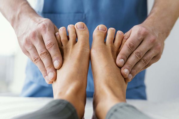 Fascitis plantar - especialista realizando un masaje en los pies para ayudar a eliminar la fascitis plantar