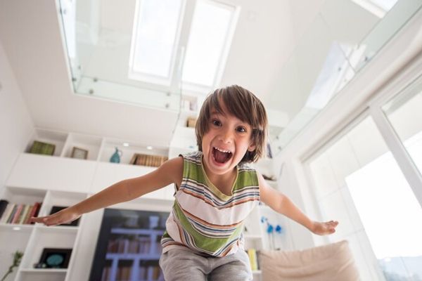 TDAH - Niño con mucha energía jugando y saltando en la casa, debido al trastorno de hiperactividad que sufre