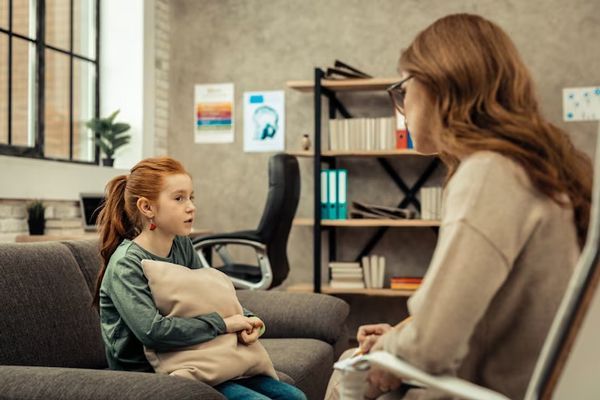 Psicopedagoga conversa con una niña para diagnosticar si posee los síntomas del trastorno por déficit de atención e hiperactividad