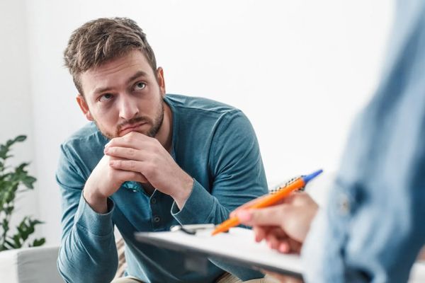 hombre joven en la consulta de la psicóloga tratando sus problemas