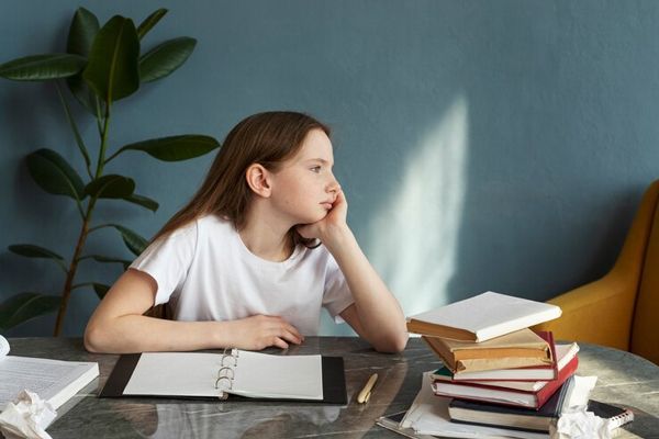 TDAH - Niña con déficit de atención distrayéndose durante las horas de estudio, lo cual afecta su aprendizaje