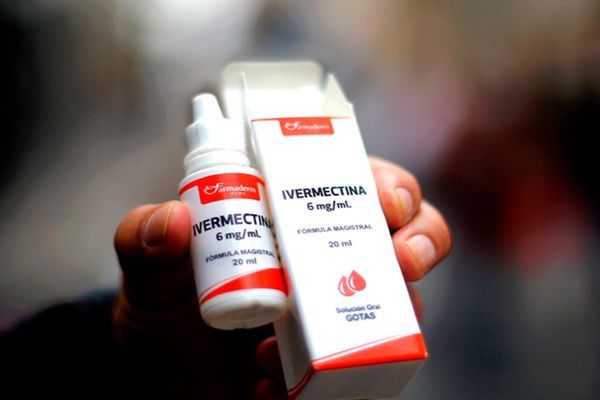 Primer plano de la mano de un paciente mostrando un medicamento y su caja para tratar la enfermedad