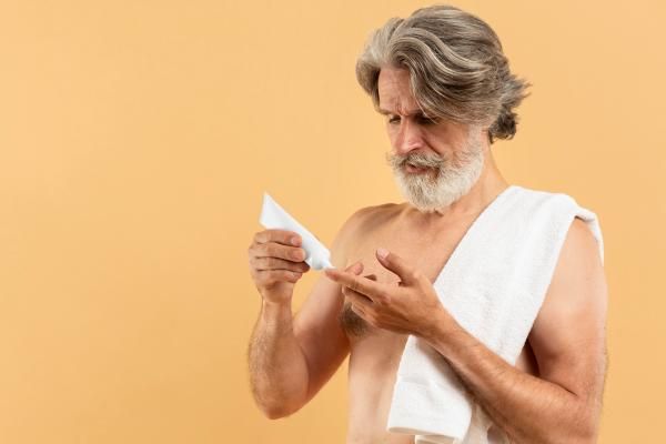 Hombre aplicando un tratamiento tópico en el cabello, para eliminar los piojos y liendres que están pegados en el cuero cabelludo