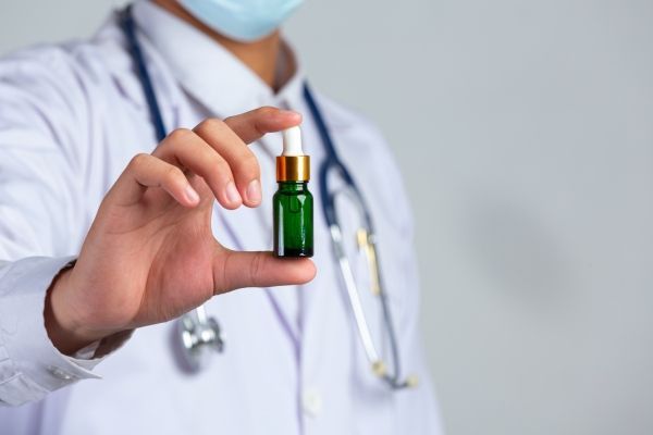CBD - medico con un frasco que contiene aceite de CBD en sus manos