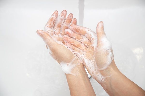 Persona lavando sus manos con abundante agua y jabón, para prevenir las infecciones causadas por hongos