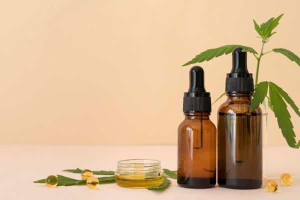 CBD - imagen de unos productos con CBD, presentados en aceites con cuentagotas o capsulas
