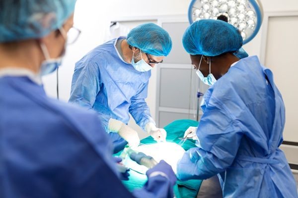 cirujano y su equipo médico en el quirófano extirpando unas hemorroides