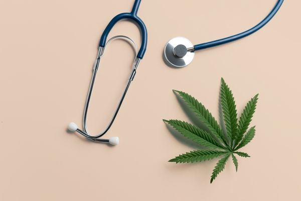 imagen de un estetoscopio al lado de una hoja de marihuana
