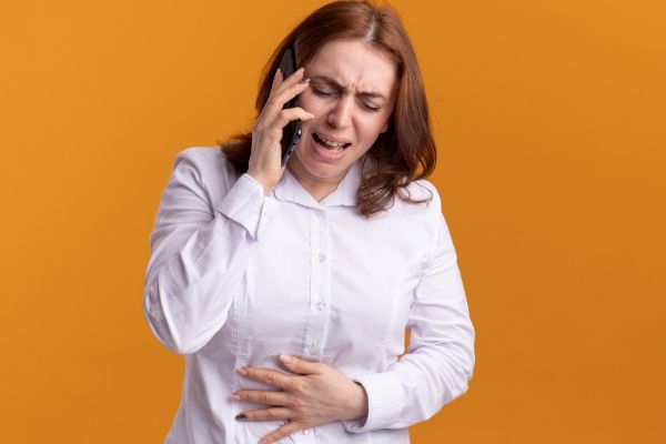 Mujer conversando por teléfono de los problemas laborales y sociales que le está ocasionando la afección, la cual está impactando en su calidad de vida
