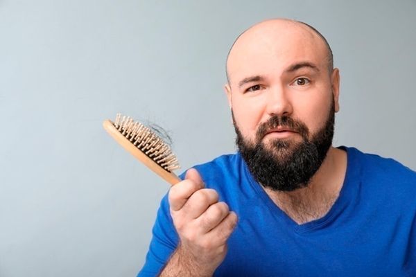 Alopecia - Hombre calvo extrañado de encontrar cabello en el cepillo
