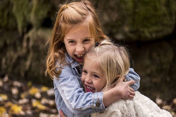 Pediculosis - dos niñas pequeñas abrazándose en el parque