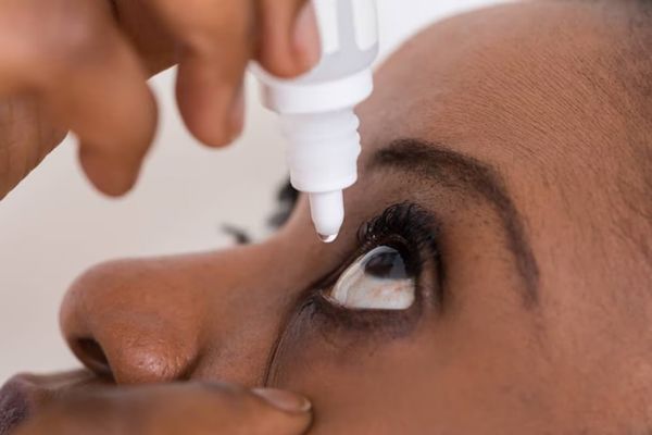 Hipertiroidismo - Mujer aplicándose un medicamento vía ocular para la enfermedad de Graves