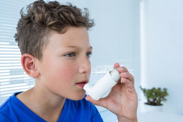 Alergias - Niño en su casa con un nebulizador el cual esta apunto de usar para tratar el asma