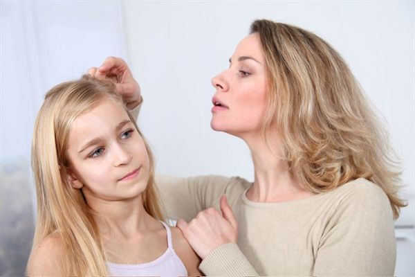 Pediculosis - Madre revisando la cabeza de su hija en busca de señales de posibles piojos