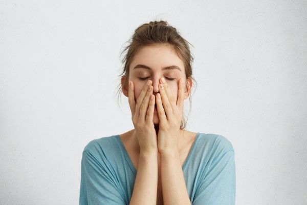anemia - Disparo en la cabeza de la joven hermosa mujer cerrando los ojos tomados de la mano en la barbilla está cansada