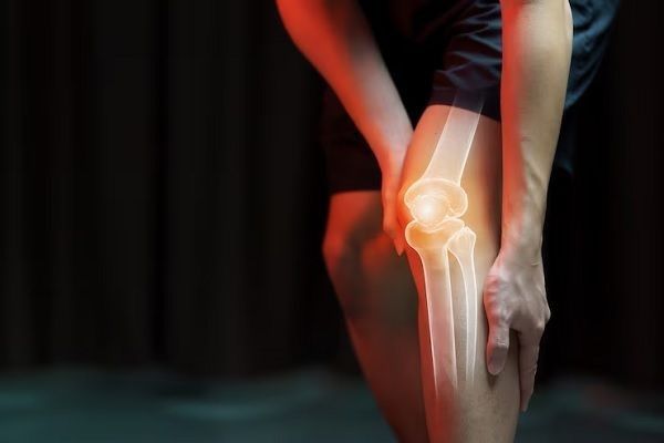 Hombre agarrándose la pierna con un fuerte dolor en la rodilla