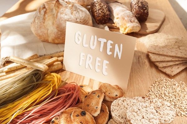 Varias pastas, pan y bocadillos sin gluten sobre fondo de madera desde la vista superior