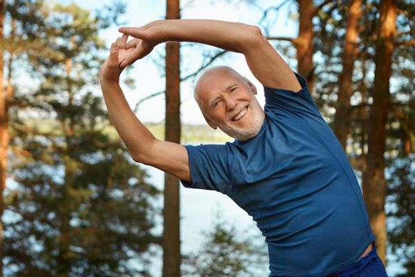 Hombre adulto mayor ejercitándose en el bosque