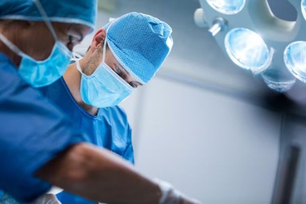 Cáncer de próstata - Cirujano en el quirófano preparándose para extirpar el cáncer de próstata de un paciente