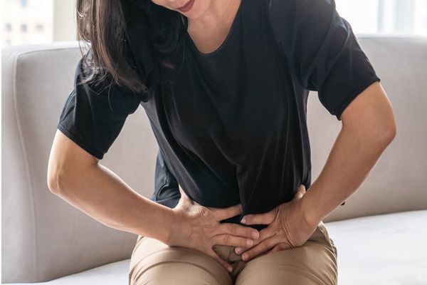 Cálculos biliares - mujer con fuertes dolores abdominales causados por los cálculos biliares