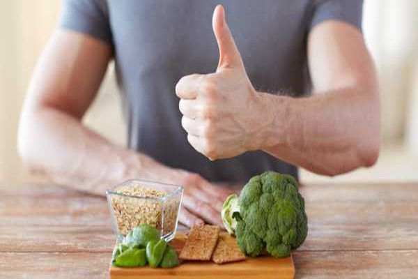 hombre en la mesa con un grupo de alimentos ricos en fibras