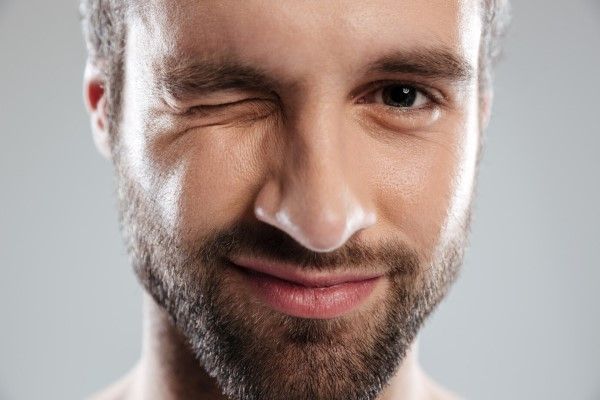 síndrome de Tourette - hombre blanco mirando a cámara con el tic de guiñar un ojo