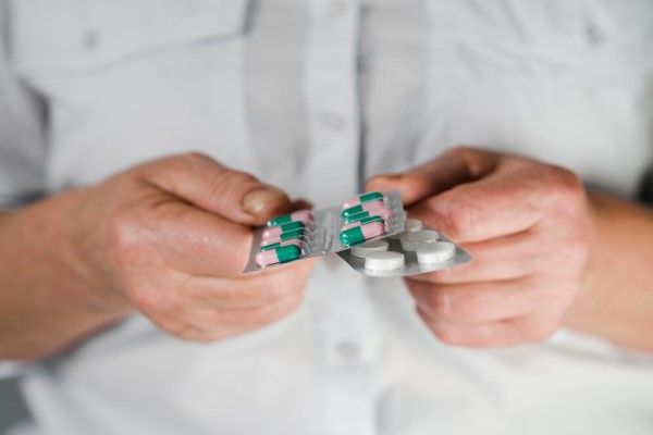 hombre con medicamentos en las manos para las molestias del procedimiento