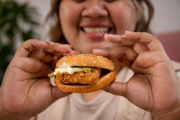 obesidad - mujer obesa muy feliz a punto de comer una comida muy poco saludable