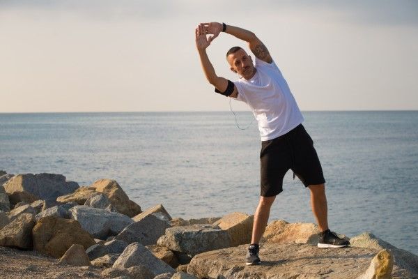 Deportista serio haciendo ejercicio en la costa