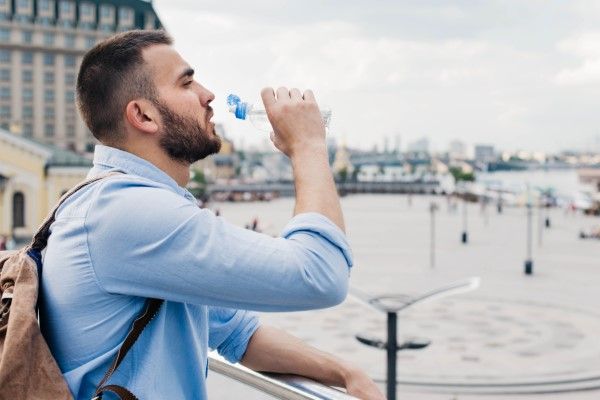 hombre blanco bebiendo agua, una buena forma de prevenir este tipo de infección