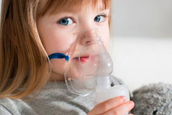 Asma - Niña con dificultades respiratorias usa una mascarilla de oxígeno para garantizar el ingreso de suficiente aire a su organismo
