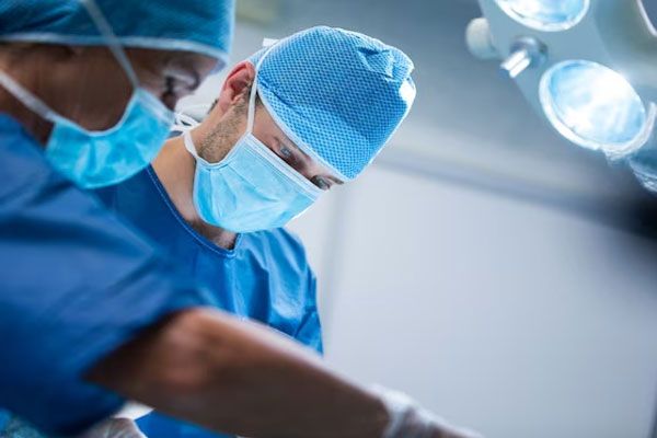 Verrugas comunes - Cirujanos especializados en dermatología estética realizan una operación menor para retirar lunares irregulares en un paciente 