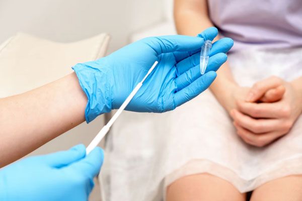 Clamidia - Ginecóloga toma una muestra de secreción vaginal de una paciente con síntomas de infección 