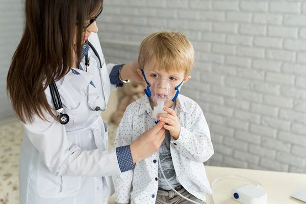 Asma - Pediatra le coloca una mascarilla de oxígeno a niño con problemas respiratorios