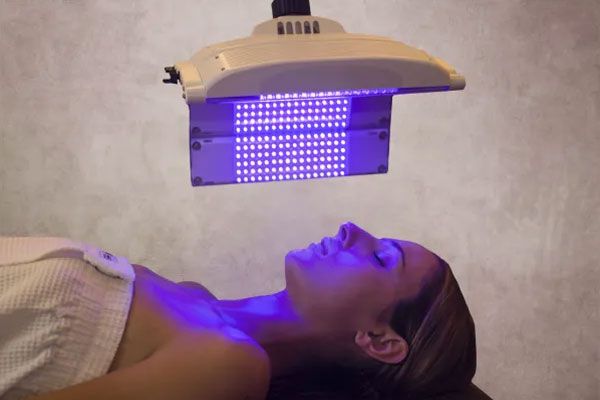 Mujer recibe tratamiento de fototerapia para tratar de unificar el tono de su piel 