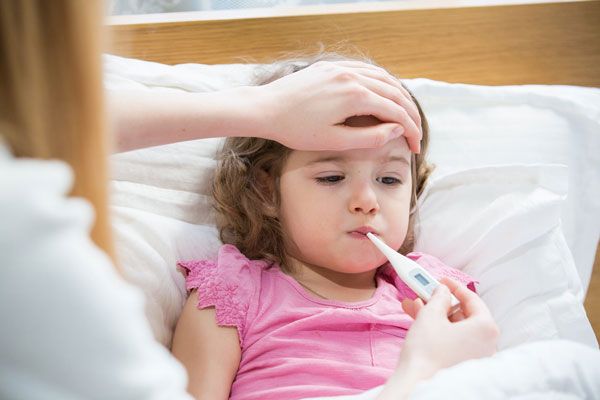 Escarlatina - Madre le toma la temperatura corporal a su hija con un termómetro tras presentar un significativo malestar 