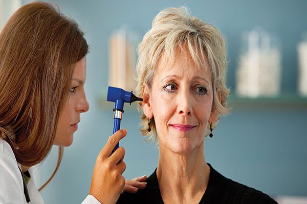 Diabetes - Doctora examina los oídos de una paciente con principios de sordera 