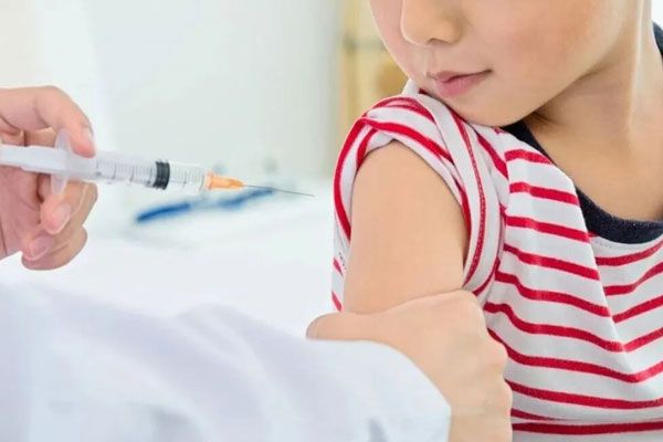 Meningitis bacteriana - Profesional de la salud sostiene el brazo de un niño para aplicar una vacuna de rigor