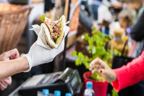 Hepatitis A - Vendedor de tacos en la calle le entrega el pedido a una cliente 