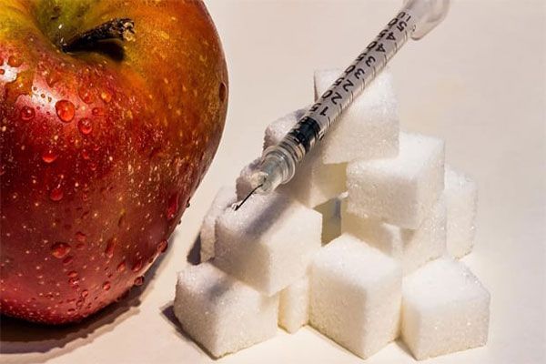 Diabetes - Cuadros de azúcar procesada y una manzana como principales fuentes de glucosa 
