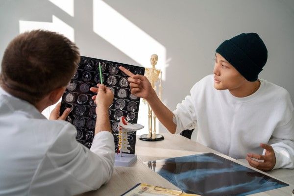paciente en la consulta del especialista revisando unos scanner de su cerebro