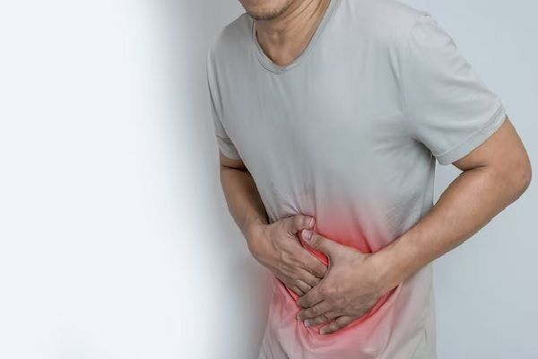 Colitis isquémica - hombre de pie llevándose la manos al abdomen por fuertes dolores