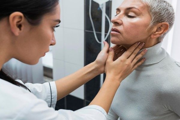 Linfoma no Hodgkin - Especialista revisando el cuello de una paciente en su consulta