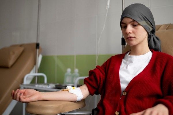 Fiebres de origen desconocido - chica joven con un pañuelo en la cabeza recibiendo un tratamiento medico intravenoso