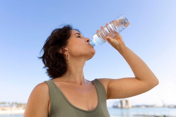 Colitis isquémica - mujer adulta bebiendo agua para hidratarse en un día caluroso